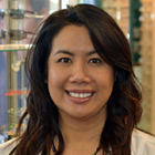 A professional portrait of optometrist Dr. Helena Nguyen, O.D., founder of Optima Optometry, smiling inside her designer eyewear boutique in Santa Clara, California.