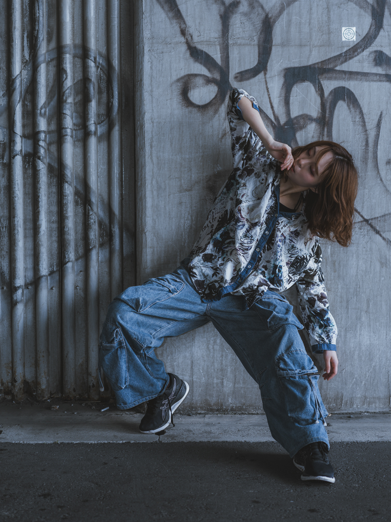 Japanese model Koishi showcasing personal street style wardrobe choices within a moody, industrial urban landscape during a rainy-day fashion editorial around Hankyu Nakatsu Station in Osaka.