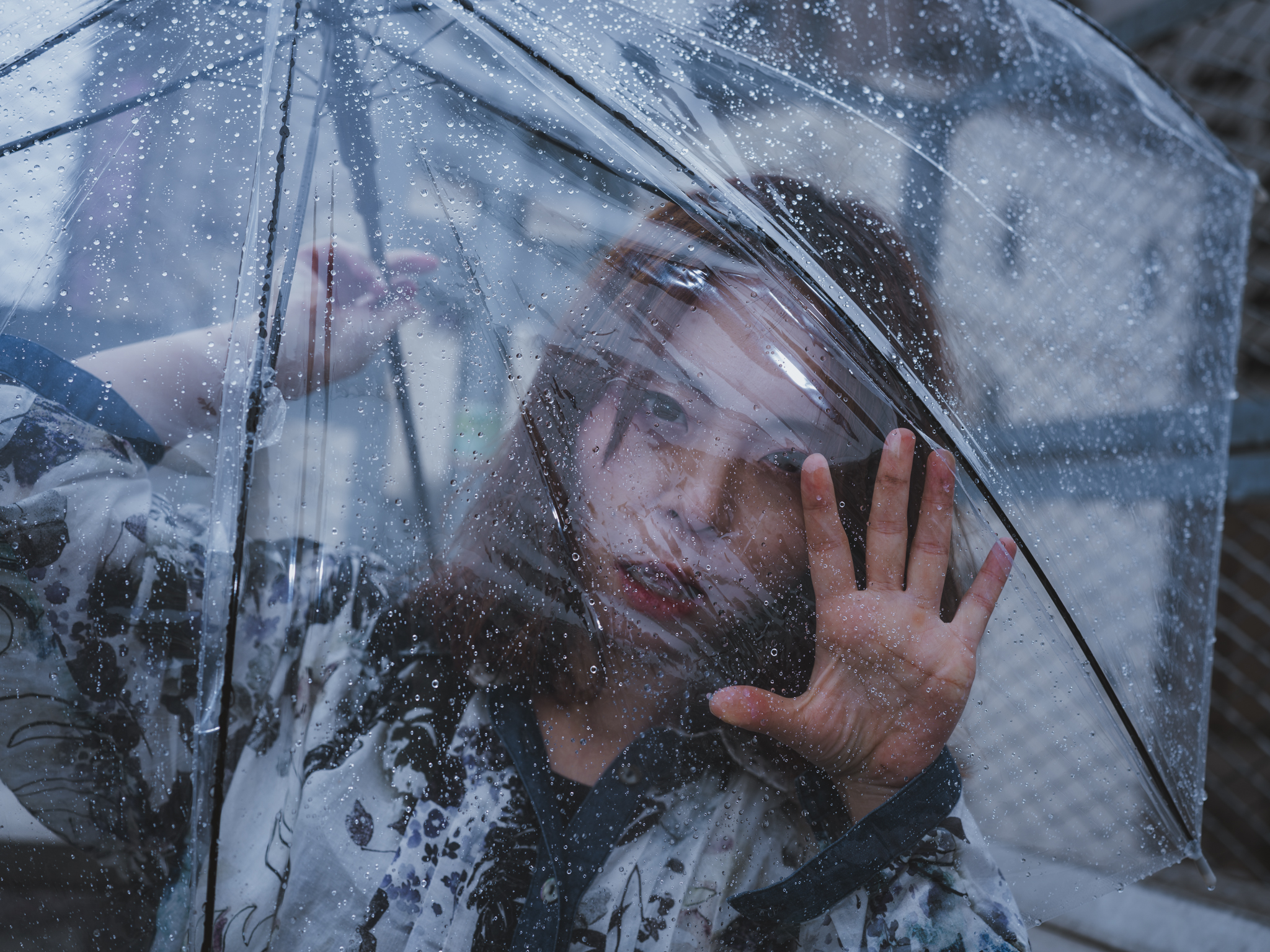 Japanese model Koishi showcasing personal street style wardrobe choices within a moody, industrial urban landscape during a rainy-day fashion editorial around Hankyu Nakatsu Station in Osaka.